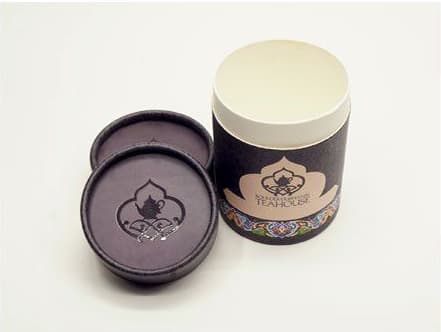 Debossed lid on a dark printed tea tube